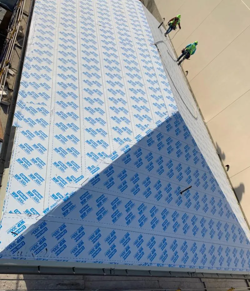 Professional roofers installing underlayment on a metal roof in Floral Park